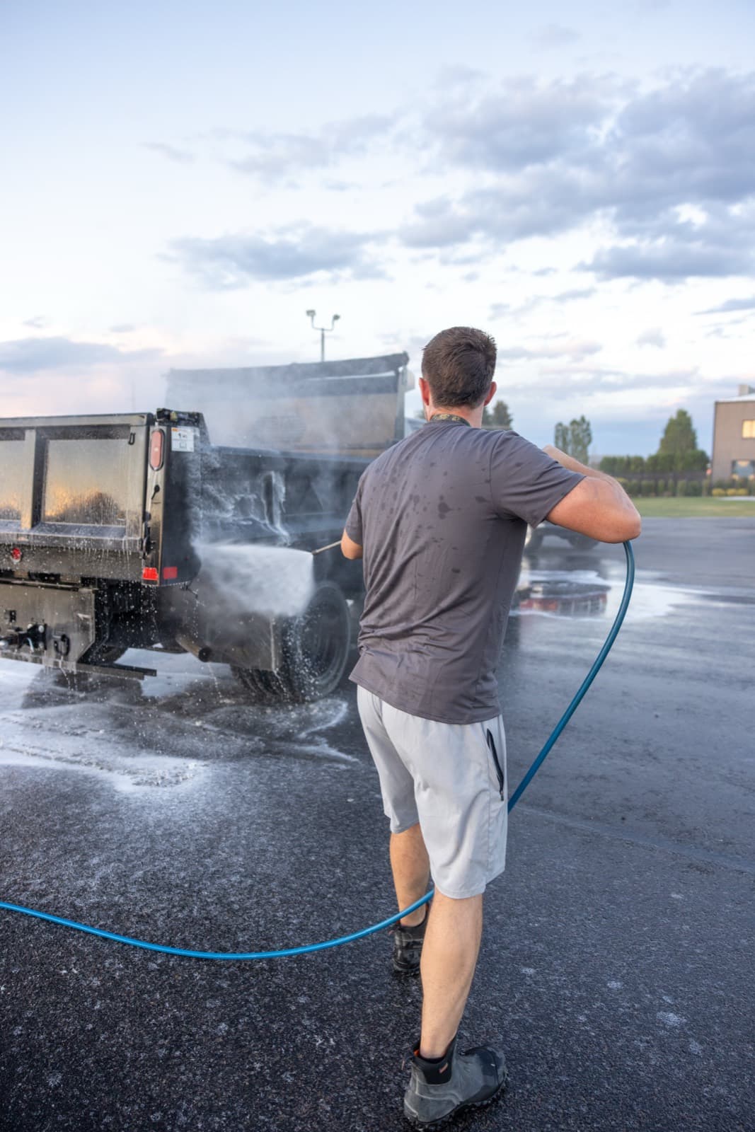 Pressure washing a dump truck on the pad
